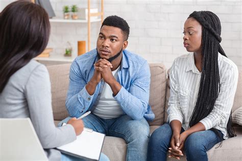 Couple Listening To Counselor S Advice Sitting On Sofa During Therapy Session International