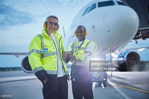 Portrait Confident Air Traffic Control Ground Crew Workers Near Airplane On Airport Tarmac Hi